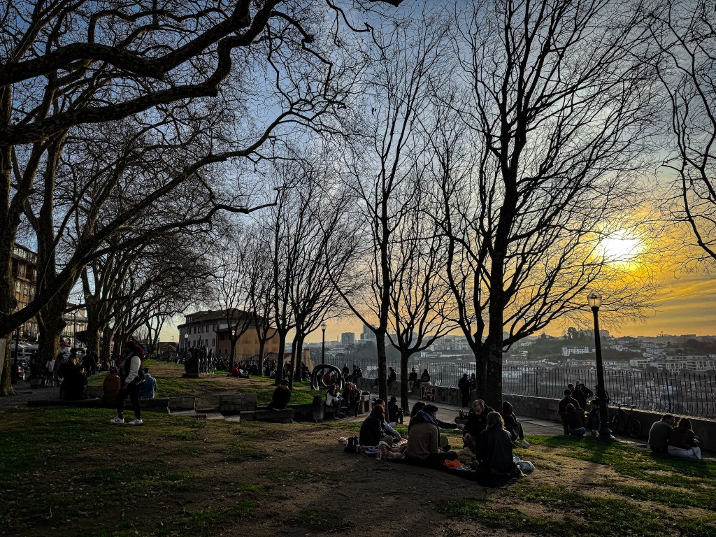 Porto locals sitting on the grass and gathered at sunset at Miradouro das Virtudes park