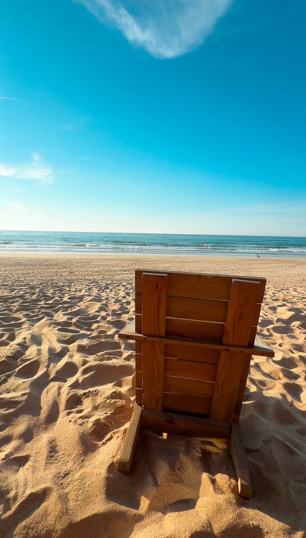 Chair in the sand looking out to the ocean in Santa Cruz, Portugal