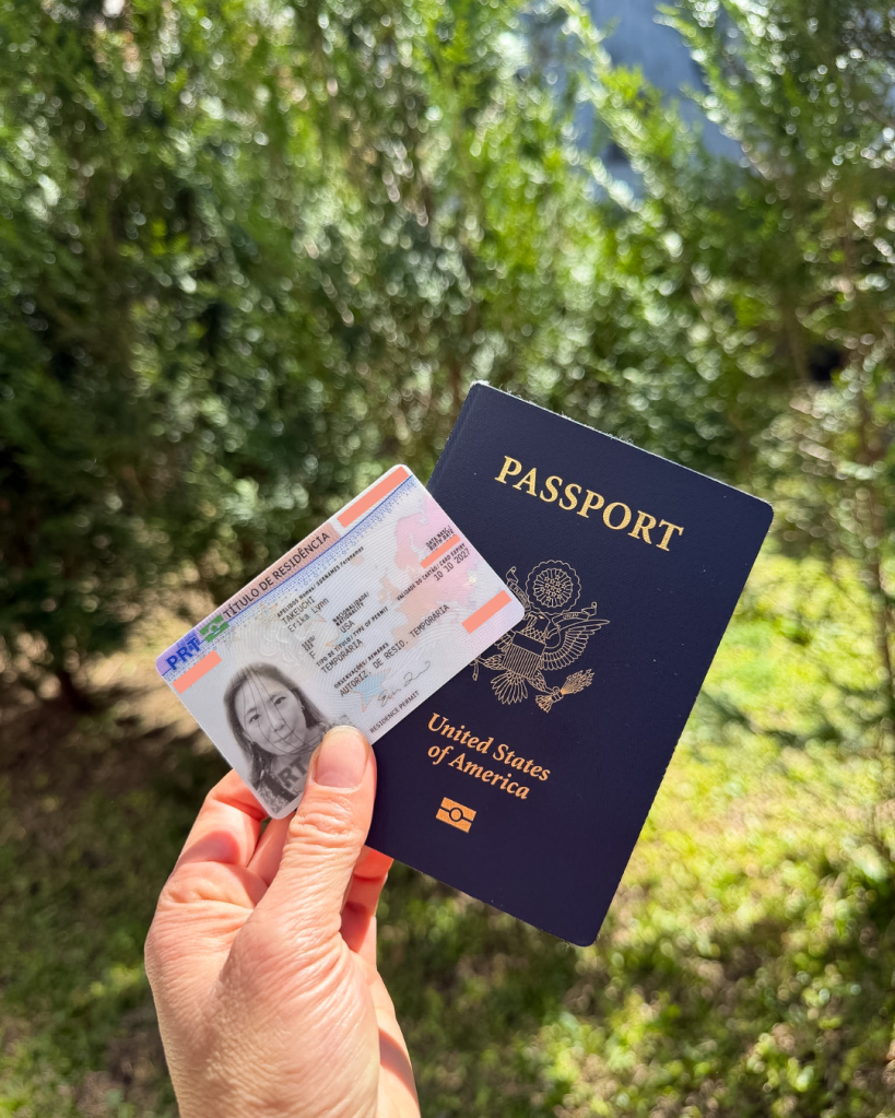 Erika holding her USA passport and Portugal residence permit